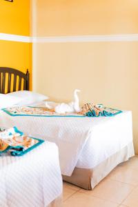 two beds with a stuffed bird on top of them at Hotel Villa del Lago in Flores