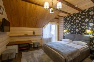 Dormitorio con cama, escritorio y TV en Korona Hotel&SPA, en Bukovel