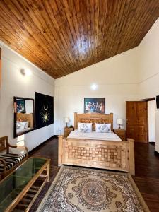 um quarto com uma cama e um tecto de madeira em Umda Hotel Pine Top em Murree