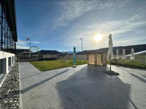 ein Gebäude mit Sonnenschirmen und der Sonne am Himmel in der Unterkunft AMANTE Hotel in Belp