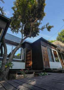 a black house with a tree in front of it at Mayan Spirit in Flores