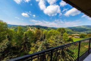 einen Balkon mit Blick auf die Bäume in der Unterkunft Krokus in Wisła