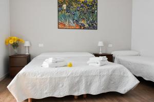 1 dormitorio con 2 camas con sábanas blancas y una pintura en B&B Ca' Rina en Preganziol