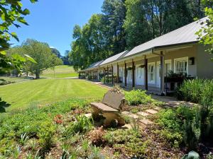 ein Gebäude mit einer Bank in der Mitte eines Gartens in der Unterkunft Bosch Hoek Golf & Lodge in Balgowan