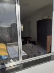 - Vistas a una habitación con cama y ventana en KITNET BRANCA NA PRAIA, en Serra