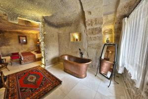 Habitación con baño grande con bañera de cobre. en Divan Cave House en Göreme