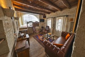 sala de estar con sofá de cuero y mesa en Divan Cave House en Göreme