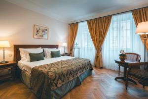 a hotel room with a large bed and windows at Appia Hotel Residences in Prague