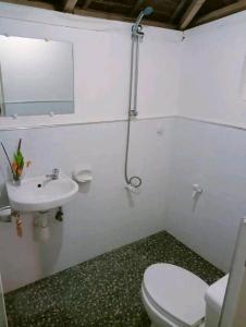 Baño blanco con aseo y lavamanos en Balai Ko Beach & Cottages en El Nido