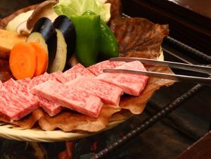 een bord met vlees en groenten bij Yunohirakan in Takayama