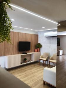 a living room with a flat screen tv on a wall at Hotel Agua Marinha in Natal