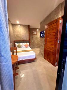 Dormitorio pequeño con cama y mesa en RL Harbor Inn, en El Nido