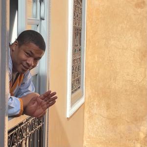 a man looking out of a window at Riad Azawan in Marrakesh