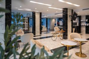 a lobby with chairs and tables and a television at Abela Al Hamra - Palestine Street in Jeddah