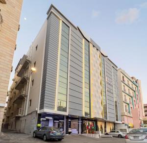 a large building with cars parked in a parking lot at Abela Al Hamra - Palestine Street in Jeddah