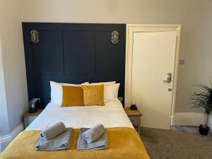 a bedroom with a large bed with two towels on it at Beach Suites in Southport