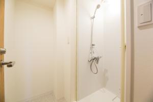 a shower with a glass door in a bathroom at あやきちゲストハウス in Daikōchō