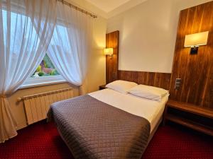 um quarto com uma cama grande e uma janela em Hotel Hawana em Bydgoszcz