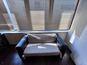 un banco sentado en una habitación con ventana en 下寺3楼, en Osaka