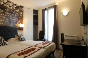 a bedroom with a bed and a desk and a window at Hôtel Princesse Isabelle in Puteaux