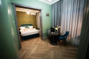 ein Schlafzimmer mit einem Bett, einem Tisch und einem Stuhl in der Unterkunft Tempus in Bukarest