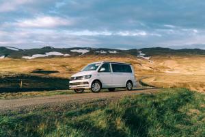 uma carrinha branca está a conduzir por uma estrada em Rent Campervans em Keflavík