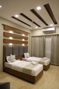 a bedroom with two beds in a room at Mount Grande "formerly known as Miot Grande" in Chennai