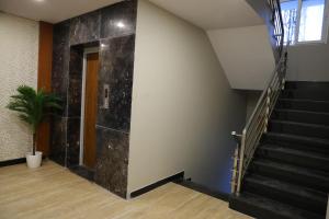 a stairwell with a black marble wall at Mount Grande "formerly known as Miot Grande" in Chennai