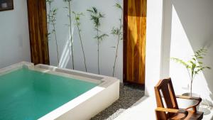 a swimming pool in a room with a wooden chair at Lugadia Villas in El Nido