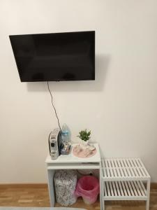 a flat screen tv hanging above a white table at Fenix Rooms in Trieste