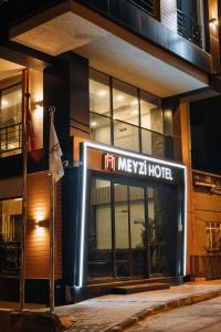 伊斯坦堡的住宿－Meyzi Hotel，夜间在大楼前的酒店标志