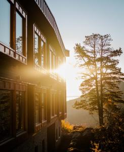 um edifício com janelas e uma árvore ao lado de um lago em Skarsnuten Mountain Resort & SPA em Hemsedal