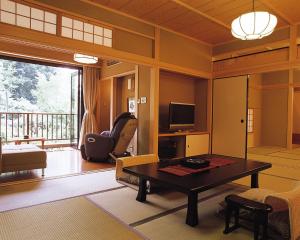 sala de estar con mesa y TV en Kasuga Hotel en Nara