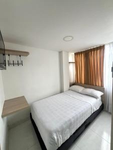 - une petite chambre avec un lit et une fenêtre dans l'établissement Hotel Adel, à Manizales