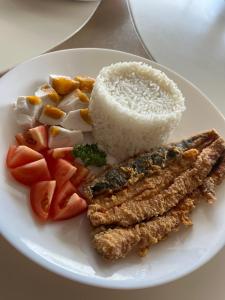 um prato branco de alimentos com arroz e legumes em AEON SUITES STAYCATION managed by ARIA HOTEL em Davao