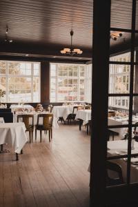 een eetkamer met tafels, stoelen en ramen bij Brøndums Hotel in Skagen