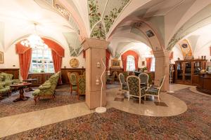 a living room with arches and chairs and a table at Hotel Dolomiti Schloss in Canazei