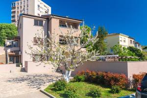 a house with a flowering tree in front of it at Pipo in Rijeka