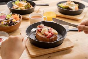 a table with bowls of food and a plate of food at R Hotel Namba South in Osaka