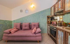 een roze bank in een keuken met een wastafel bij Cozy Apartment In Kastel Stari With Kitchen in Kaštela