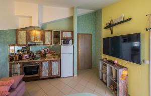 een keuken met een witte koelkast en een televisie bij Cozy Apartment In Kastel Stari With Kitchen in Kaštela