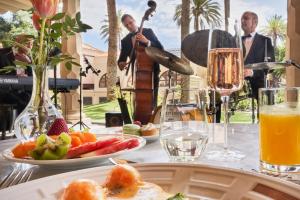 una mesa con un plato de comida y un hombre tocando un violín en Santa Catalina, a Royal Hideaway Hotel en Las Palmas de Gran Canaria