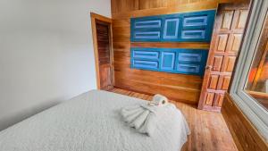 a bedroom with a bed with a wooden wall at Mayan Spirit in Flores