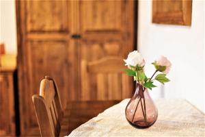 Eine Vase mit Blumen auf einem Tisch in der Unterkunft Gościniec Horb in Wetlina