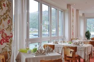 una sala da pranzo con tavoli con tovaglie bianche di Weinhotel Landsknecht a Sankt Goar