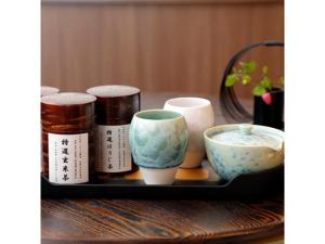 - un plateau avec des bols et des tasses sur une table dans l'établissement THE JUNEI HOTEL Kyoto Imperial Palace West - Vacation STAY 74897v, à Kyoto