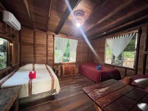 a bedroom with a bed and a table in a room at Hotel Mon Ami in El Remate