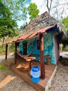 a small blue house with a thatched roof at Hotel Mon Ami in El Remate