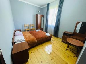 um quarto com uma cama, uma mesa e um espelho em Guesthouse am Museum em Mestia