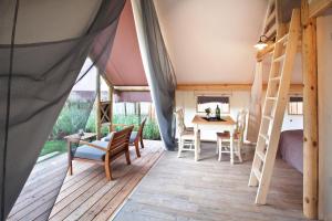 LjubnoにあるCharming Slovenia - Herbal Glamping Resort Ljubnoのテント(テーブル、椅子付)が備わる客室です。